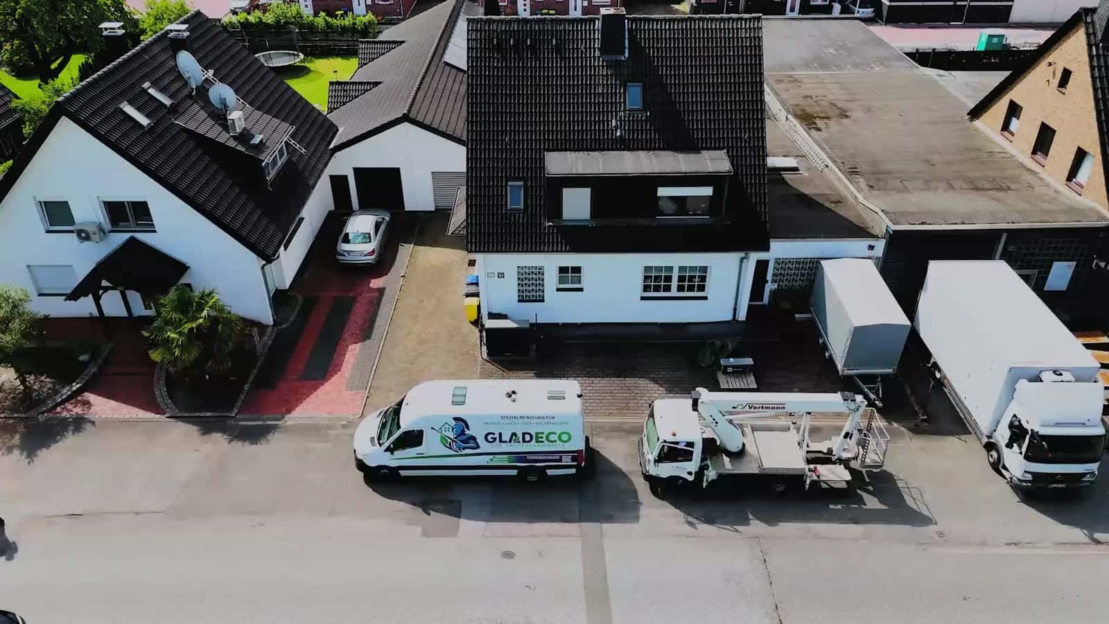 Luftaufnahme eines betreuten Wohnobjekts mit zwei GLADECO-Servicefahrzeugen