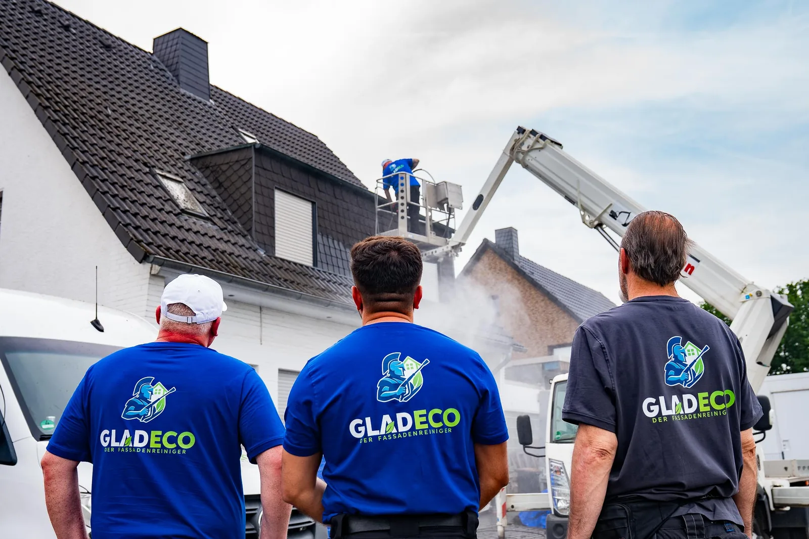 GLADECO-Mitarbeiter in Arbeitskleidung vor einem betreuten Objekt